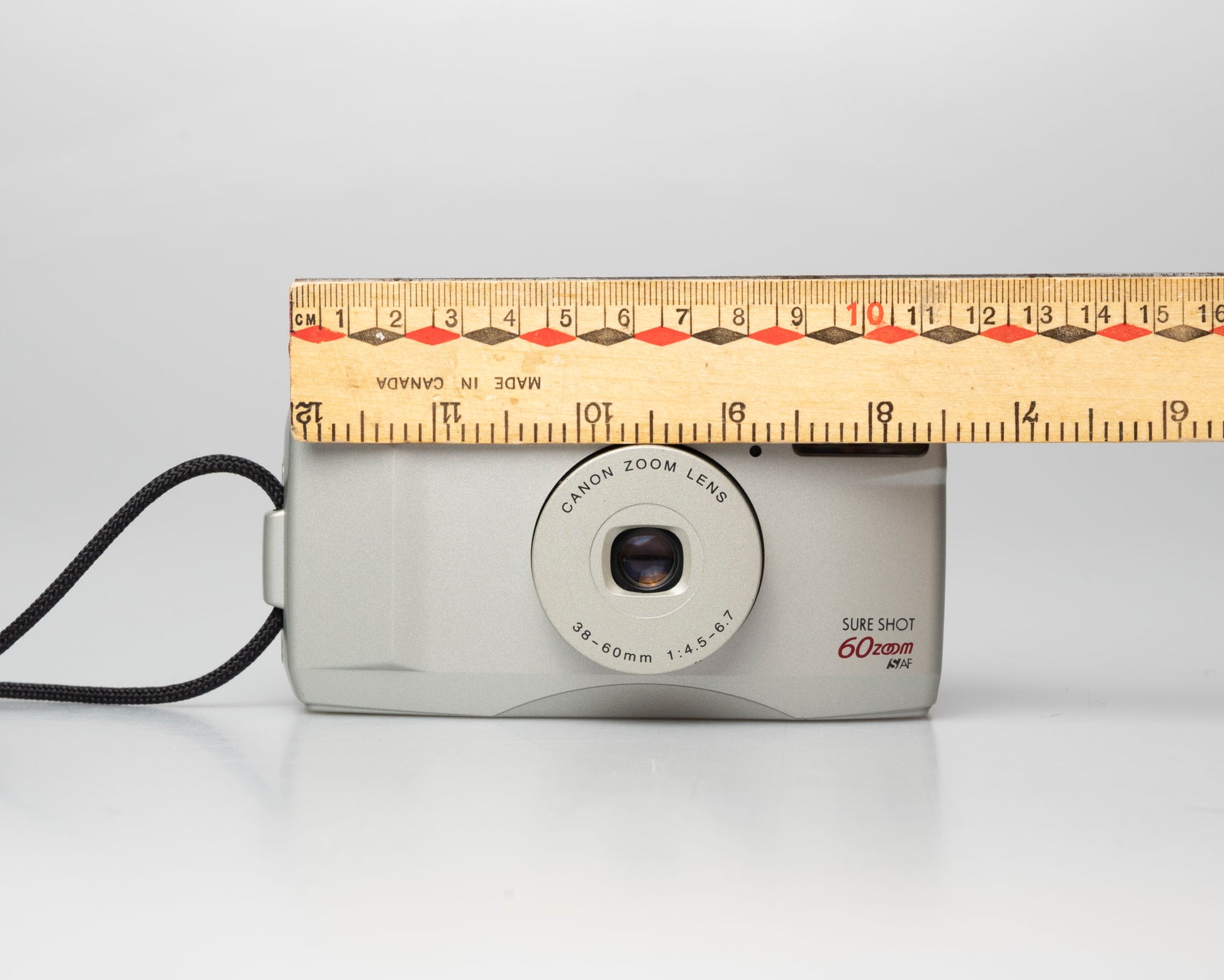 Canon Sure Shot 60 Zoom 35mm point-and-shoot camera; front view with ruler for scale