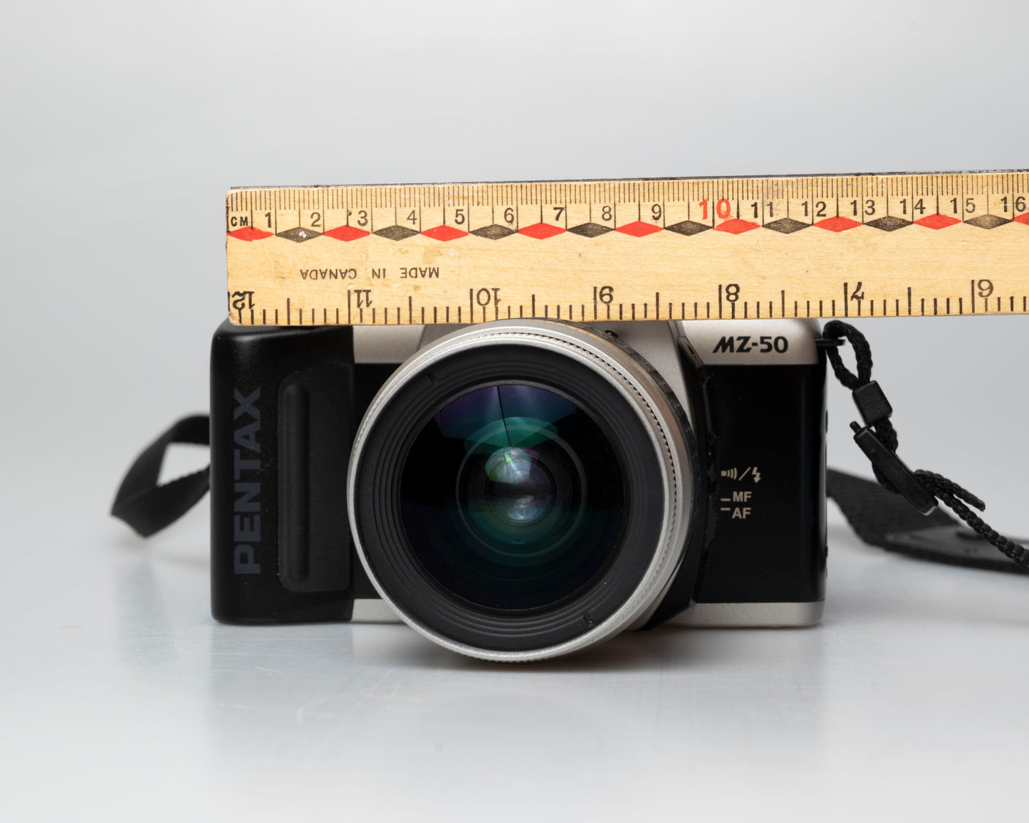 Pentax MZ-50 35mm film camera with kit zoom lens; front view with ruler for scale