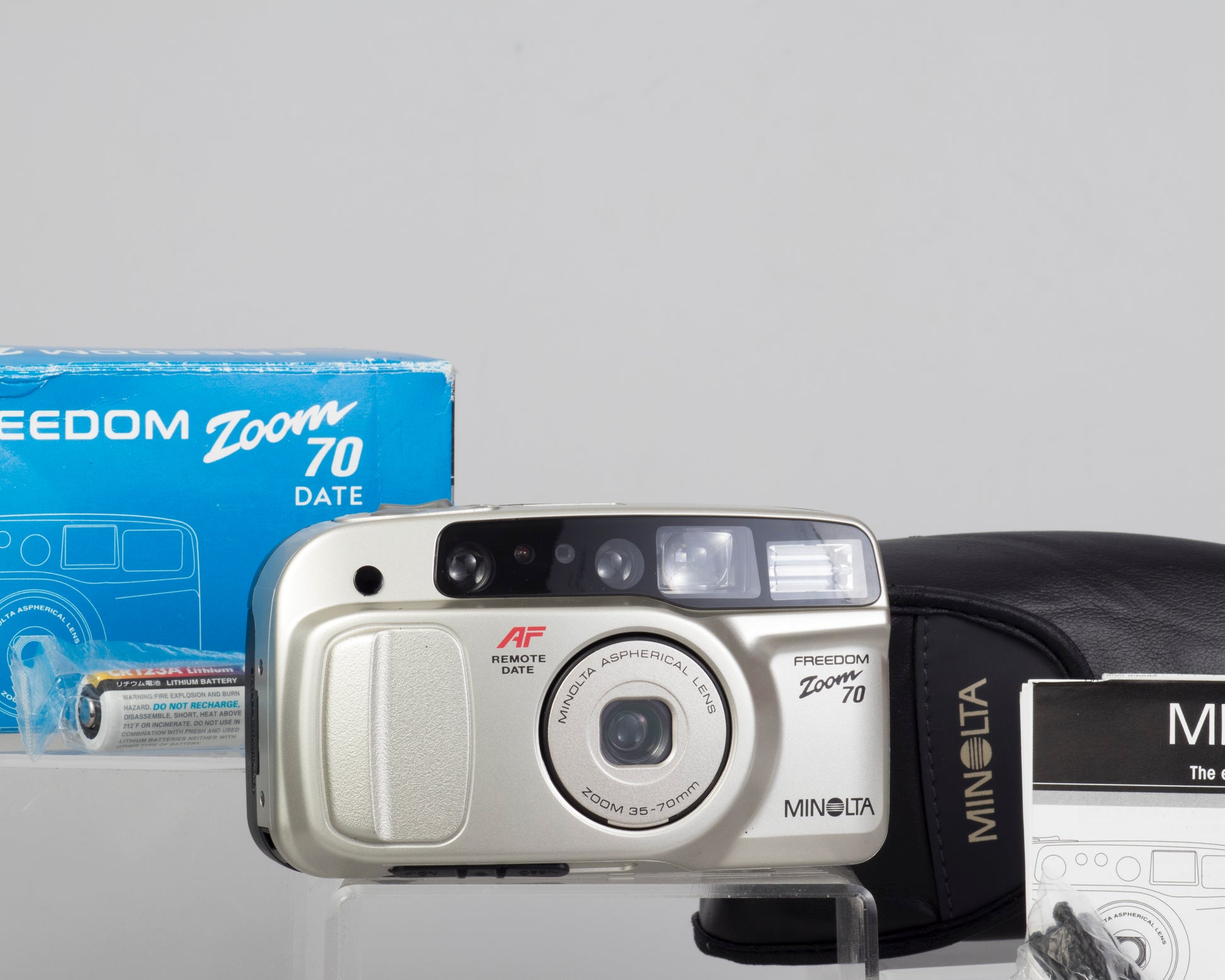 The Minolta Freedom Zoom 70 Date with its original box, case,  strap, manual, and (likely expired) battery