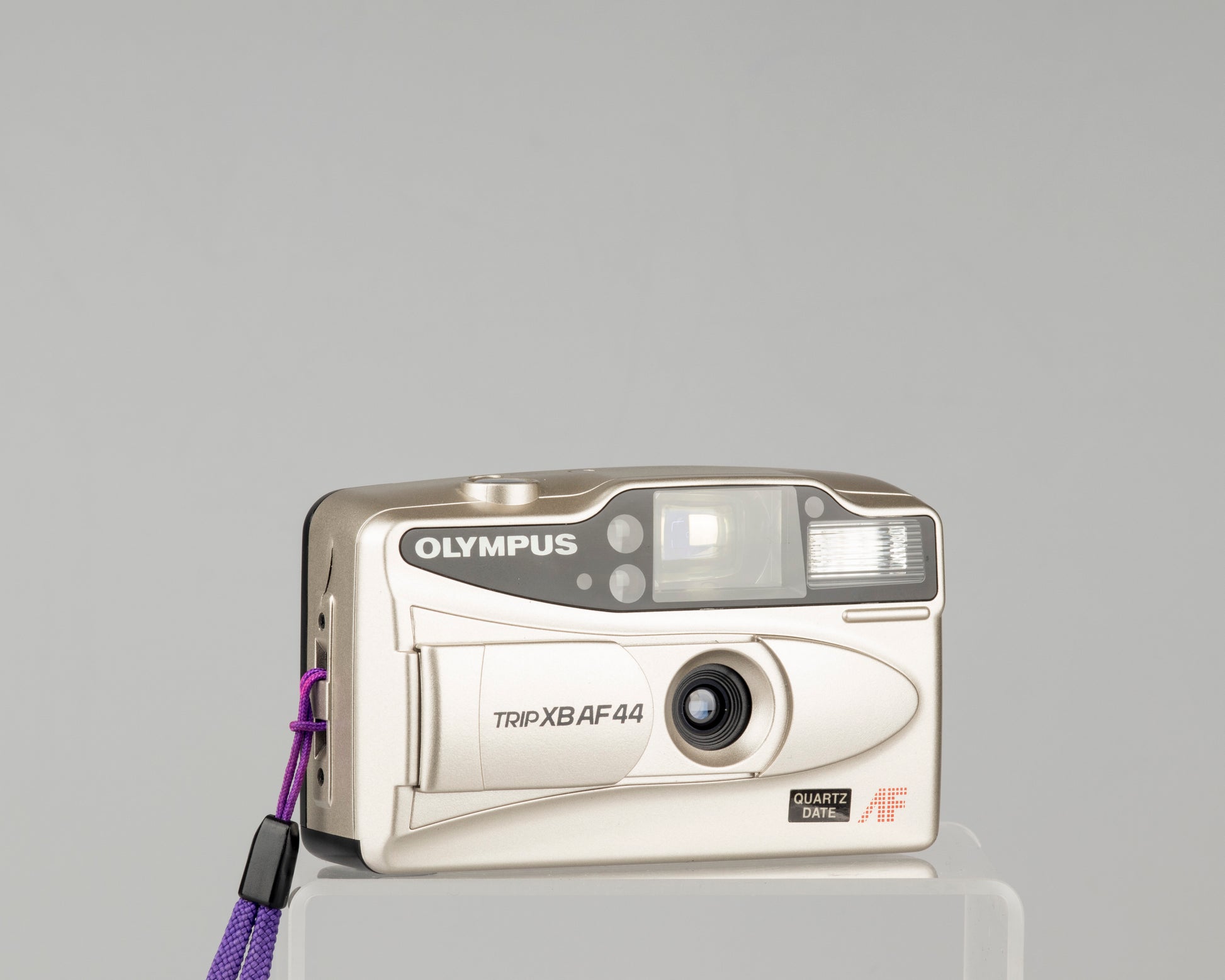The Olympus Trip XB AF44 is a compact 35mm film camera featuring a 27mm wide-angle lens