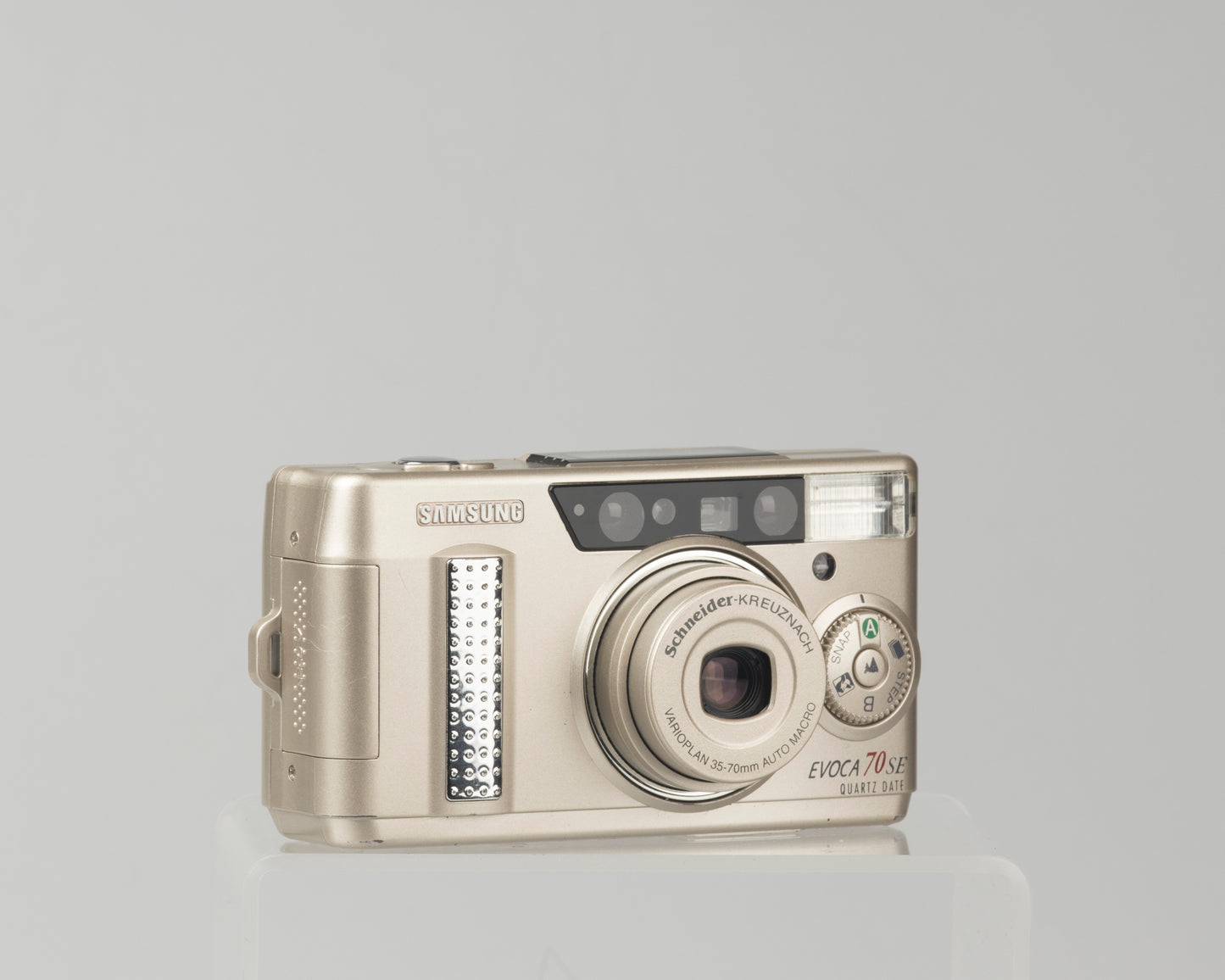 The Samsung Evoca 70 SE (the same cameras the Samsung Vega 77i and the Rollei Prego 70); a good quality ultra-portable 35mm cameras with a Schneider-Kreuznach Varioplan lens 