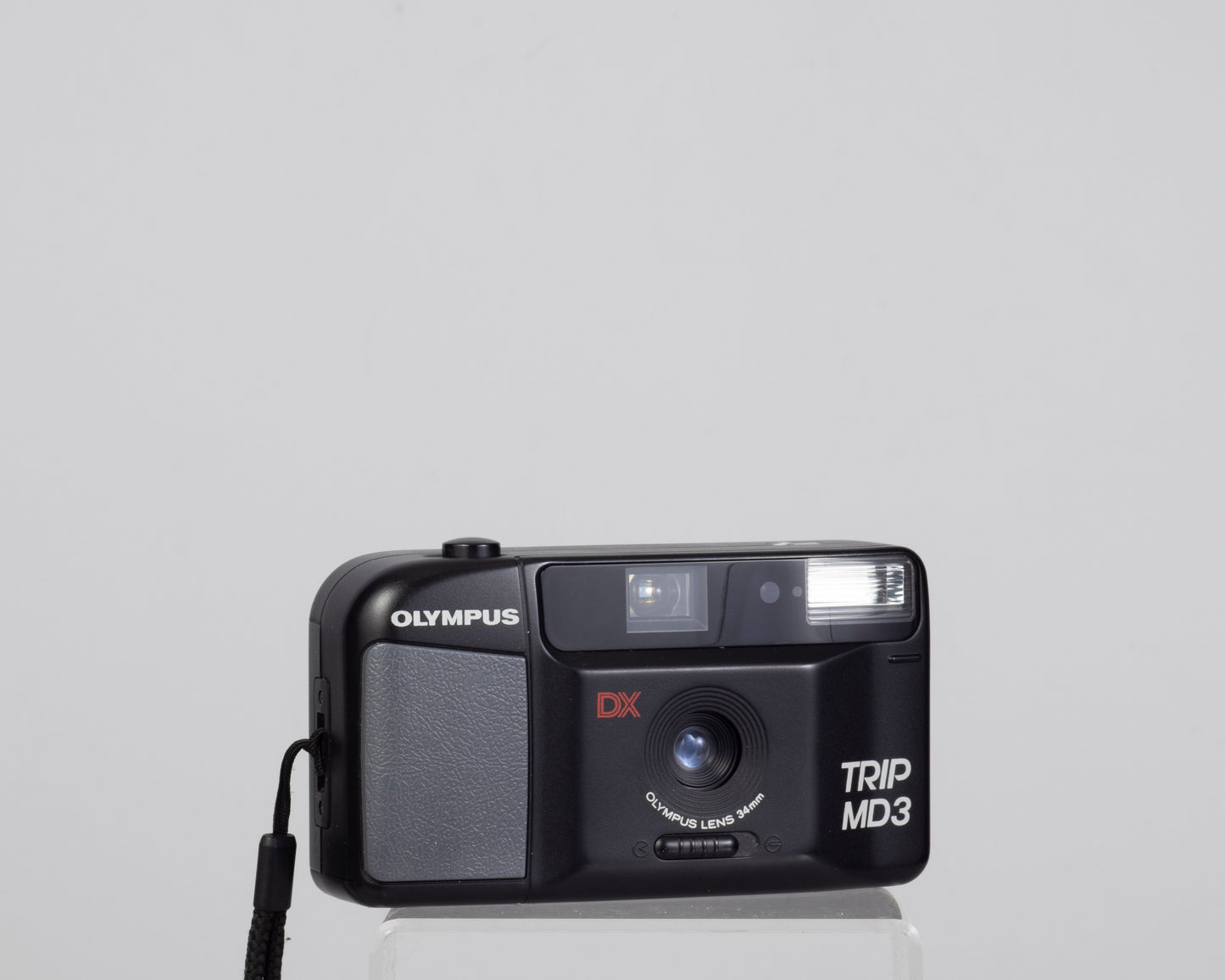The Olympus Trip MD3 is a simple compact 35mm film camera featuring a fixed 34mm lens.