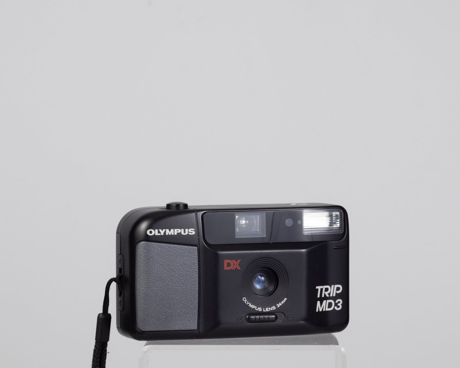 The Olympus Trip MD3 is a simple compact 35mm film camera featuring a fixed 34mm lens.