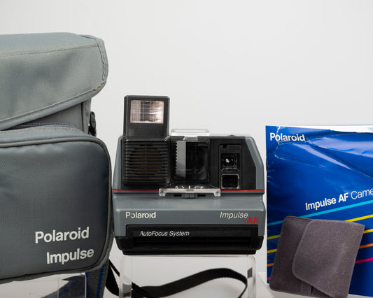 Polaroid Impulse AF instant camera with original case, prism lens filter, and manual (serial C4K18579YDCA)