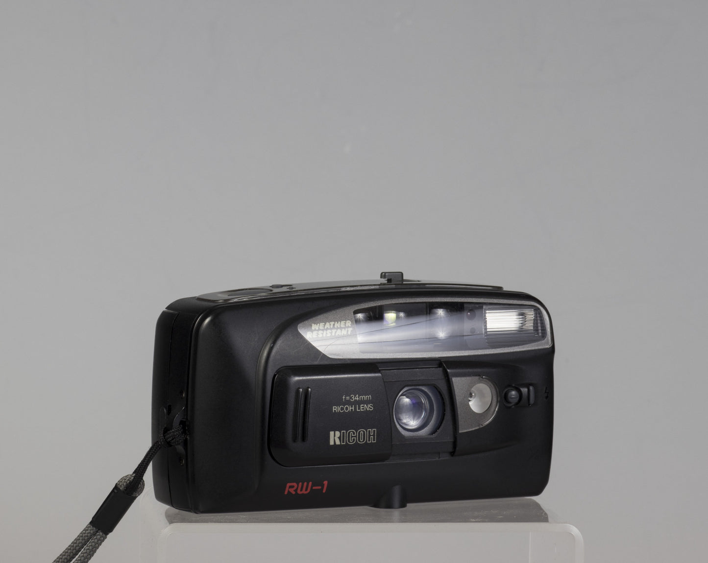 The Ricoh RW-1 Date is a 35mm film point-and-shoot camera from circa 1993. This camera features a 34mm lens and a weather resistant housing