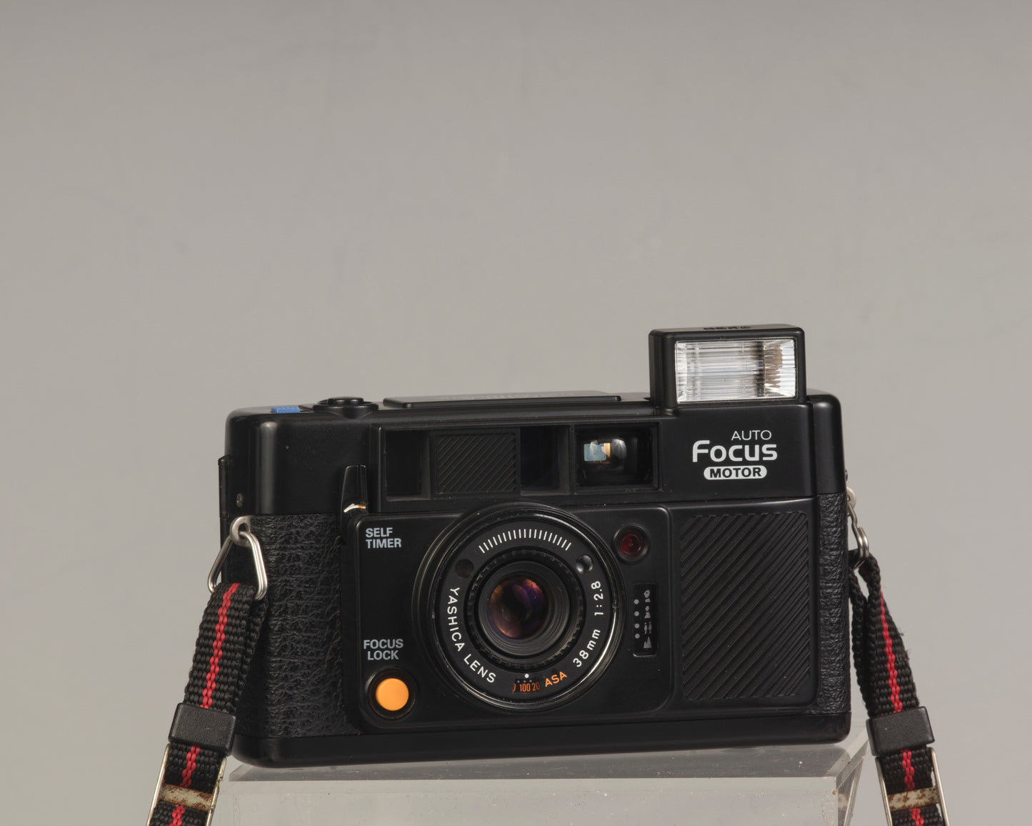 The Yashica Auto Focus Motor (shown with flash popped up) is a classic 35mm point-and-shoot film camera featuring a 38mm f2.8 lens
